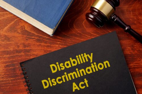 A Disability Discrimination Act (DDA) book with a gavel and a legal text.